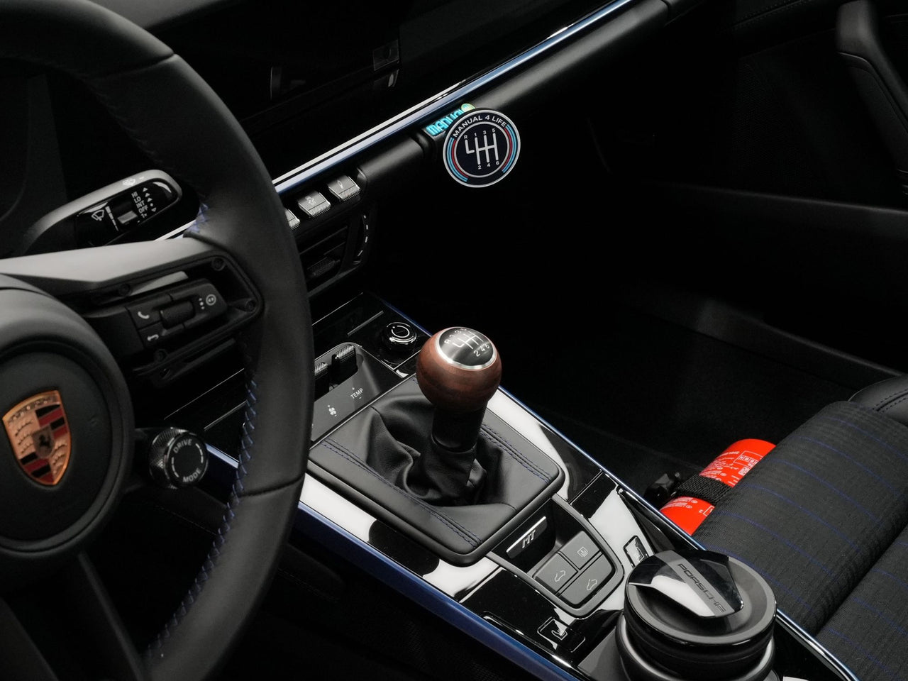 GT3Designs V2 charging mount seated in a Porsche 992 glovebox with a phone attached and charging.